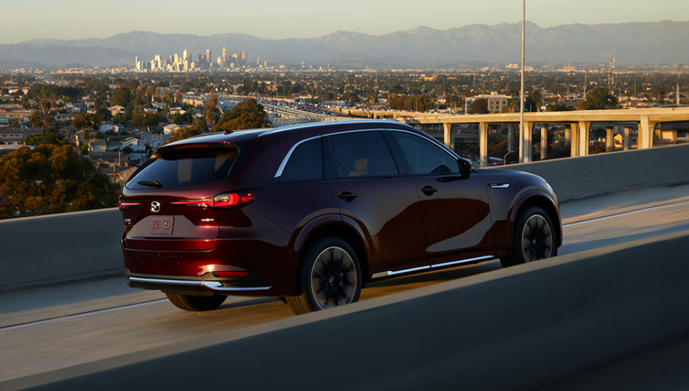 Red Mazda CX-90 driving on the road