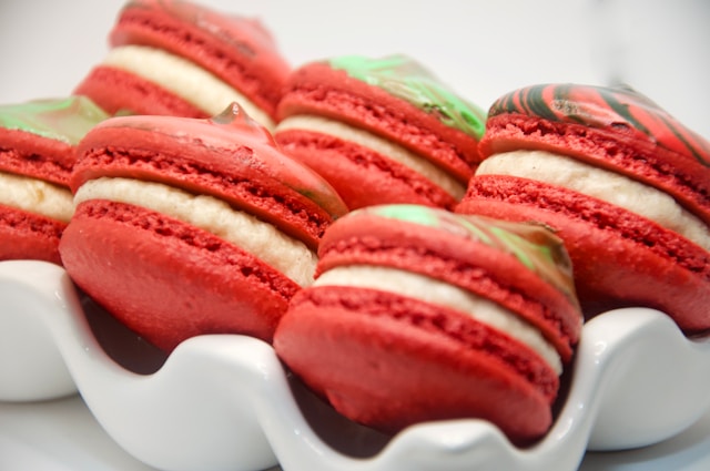 A close up of a plate of red and white macaroons